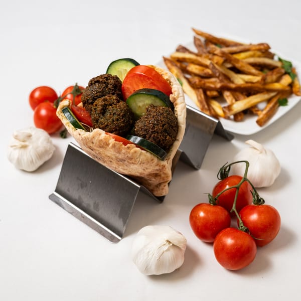 Pita Pocket Eatery's falafel pita with tomatoes and cucumbers, served with fries, garlic, and cherry tomatoes.